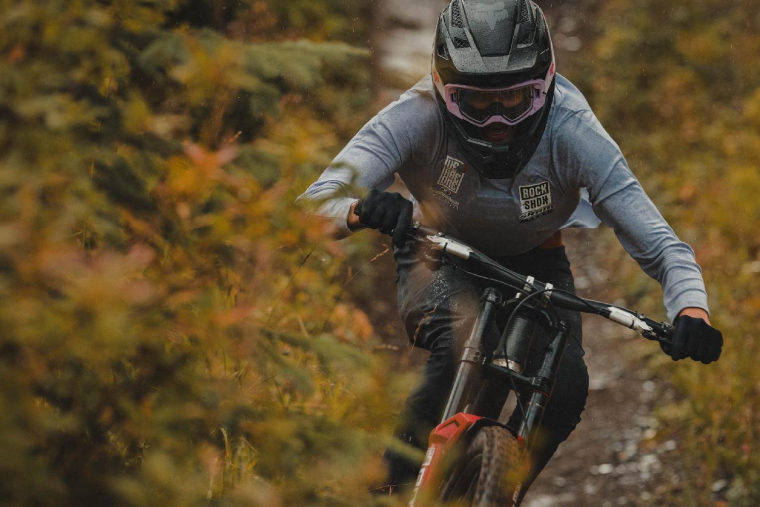 Mountain biker navigating a forest trail in autumn.