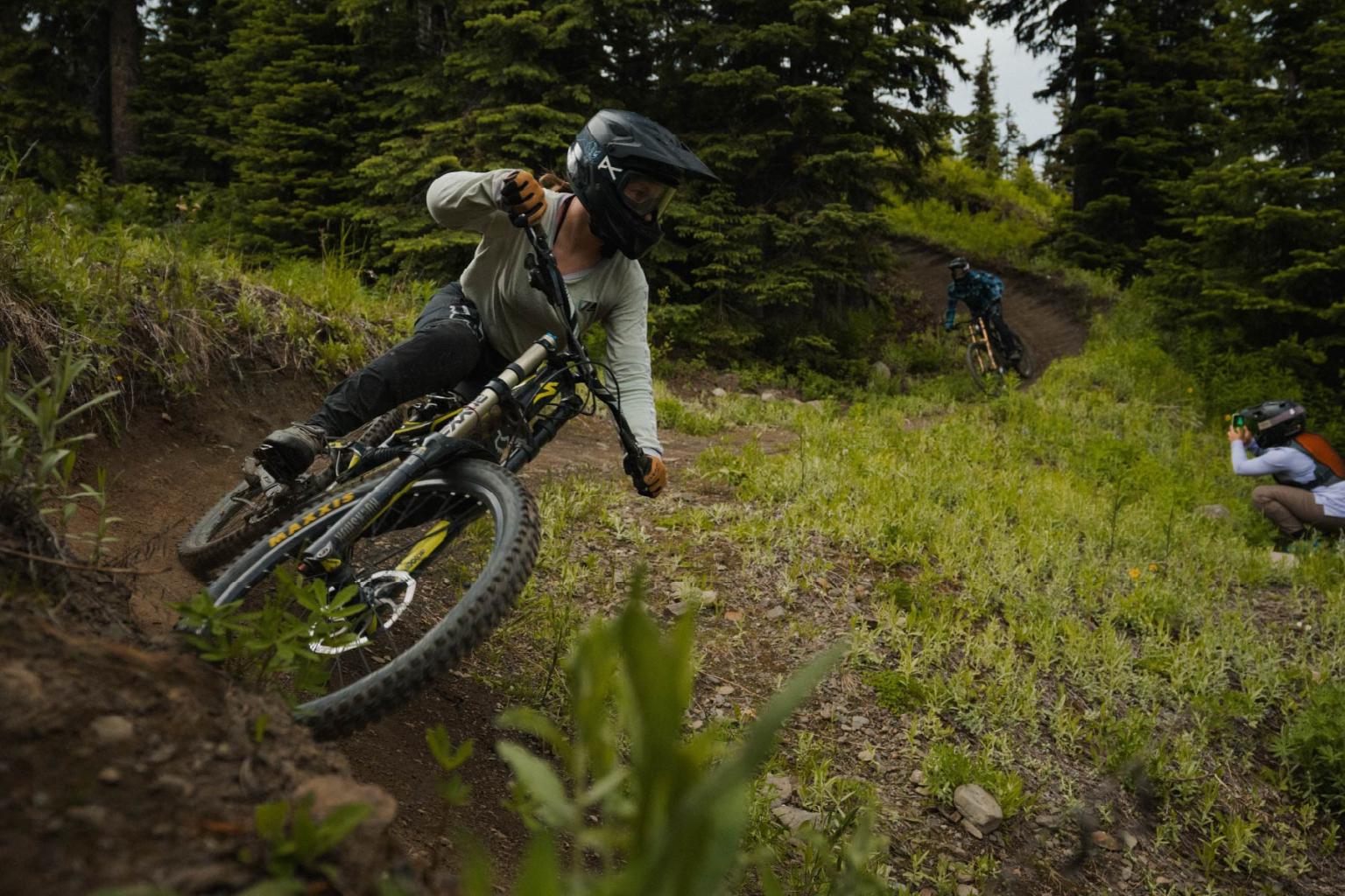 Mountain bikers racing on a wooded trail.