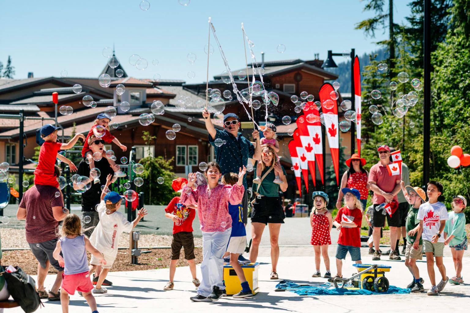 Celebration with kids and adults playing with bubbles, red and white decorations.