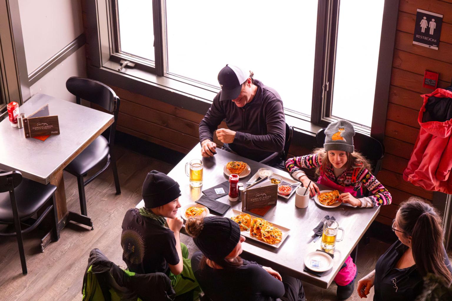 Family eating at a dining table in a cozy restaurant.