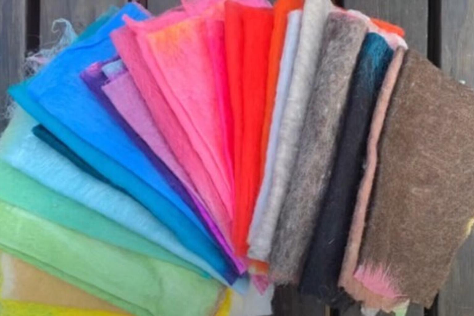 Colorful fabric swatches fanned out on a wooden surface.