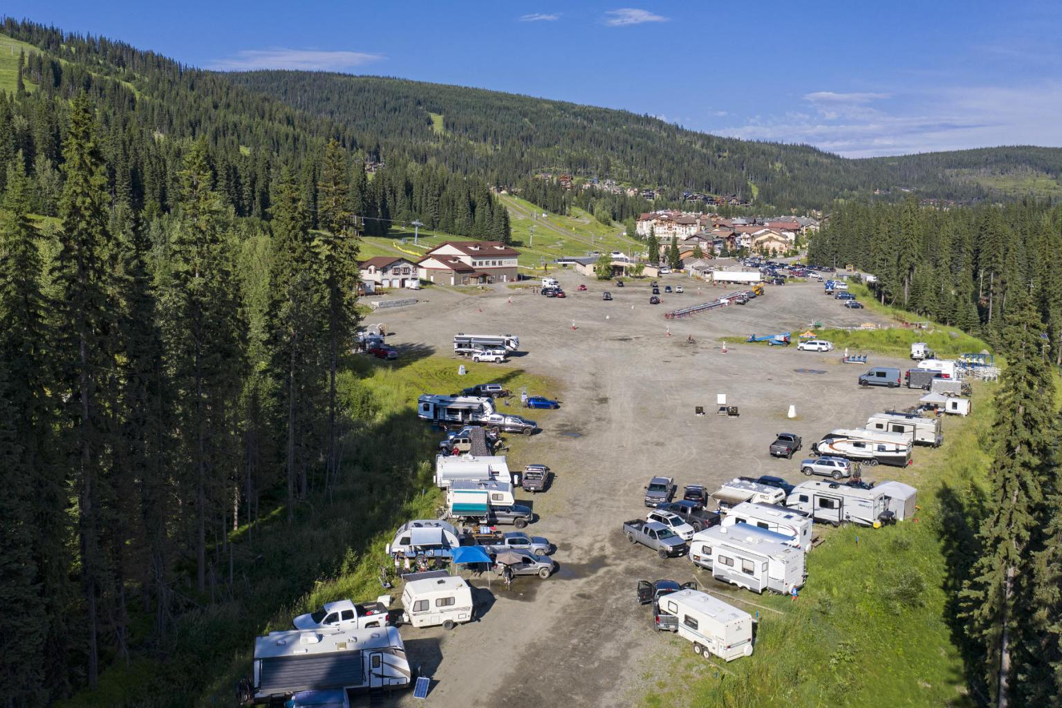 Aerial view of RVs parked in a forested mountain area.