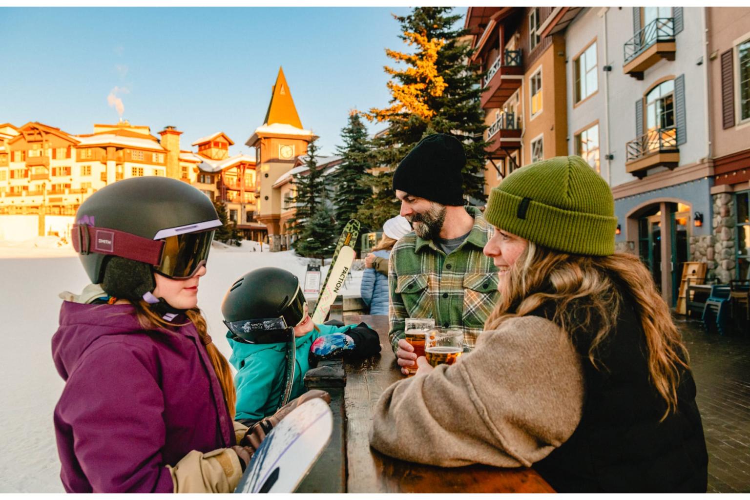 Two kids in ski gear meet up with their parents in snowy Sun Peaks village, slopeside.