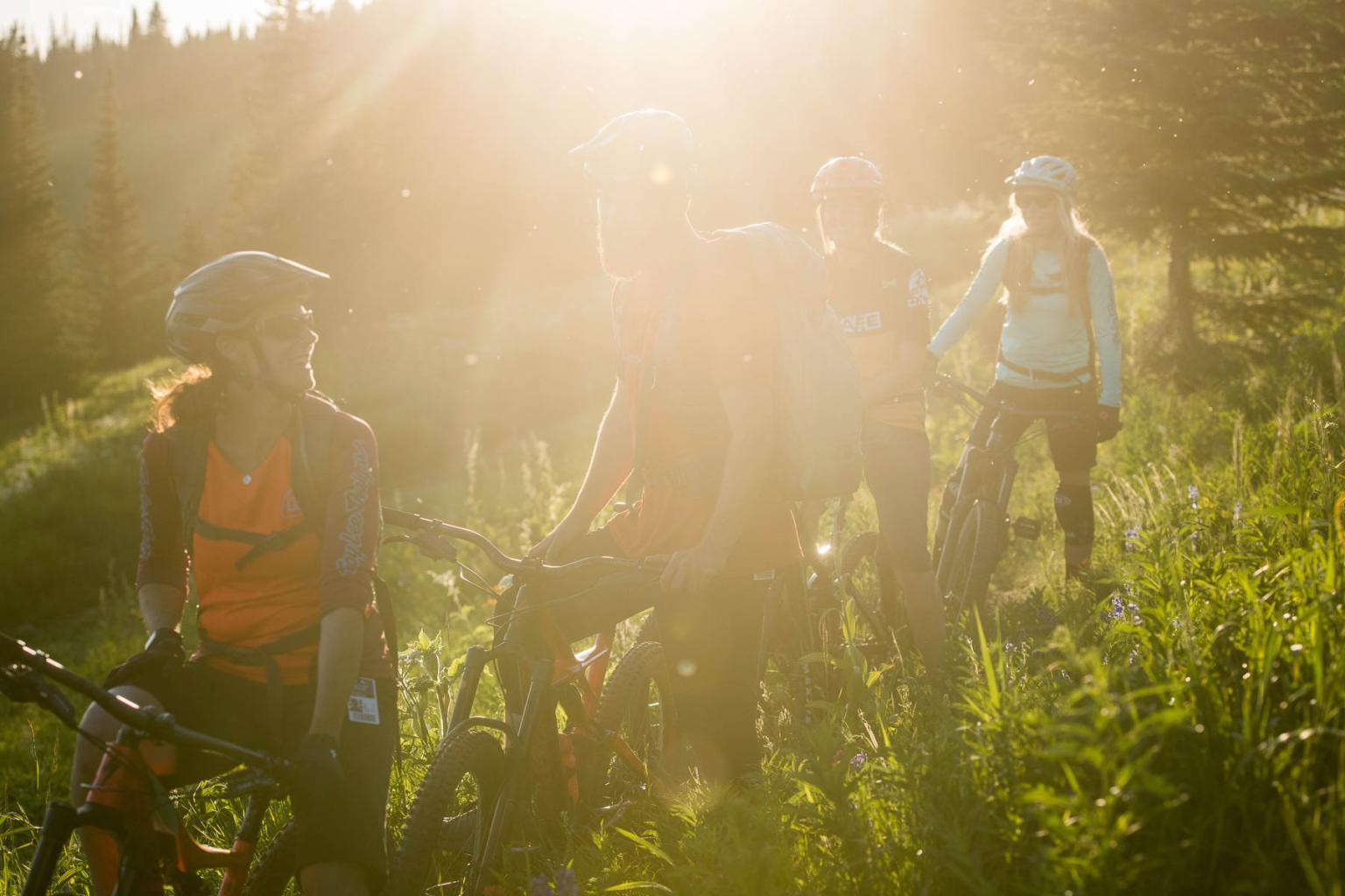 friends riding trail bikes in sun peaks