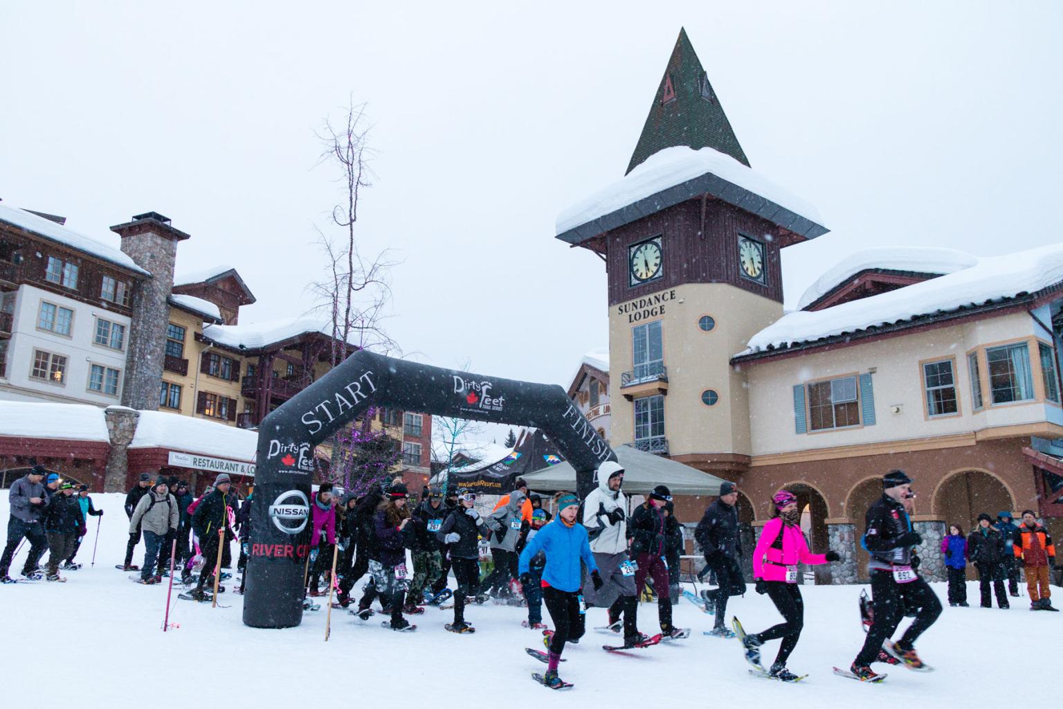 People starting a snowshoe race beside the clocktower 