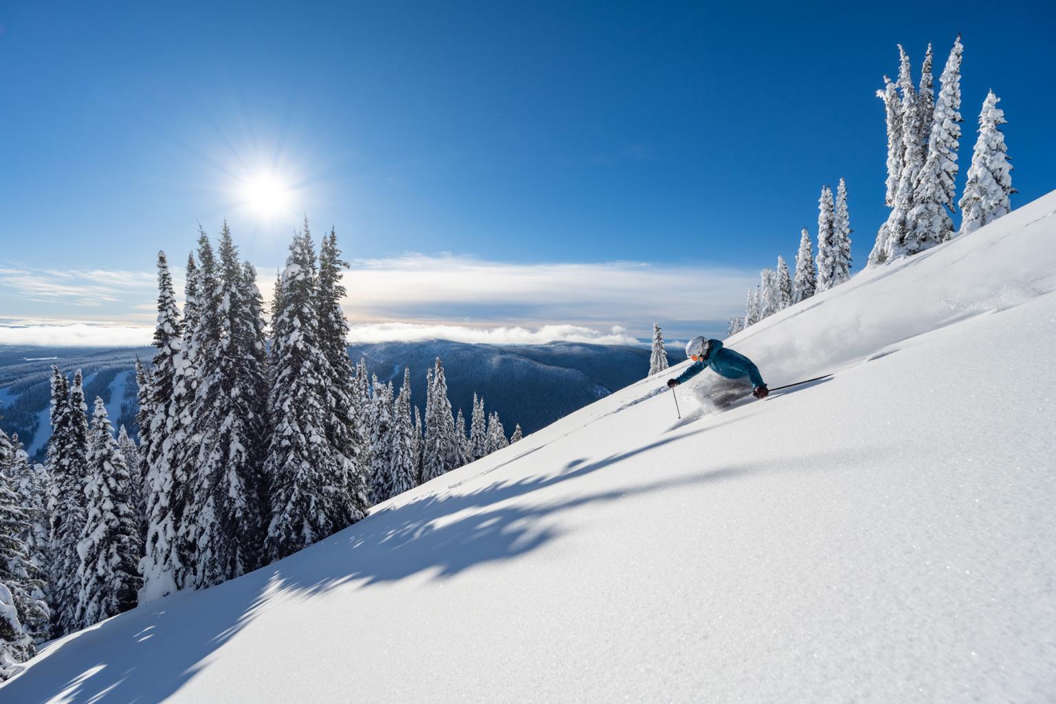 Skier in powder with blu sky