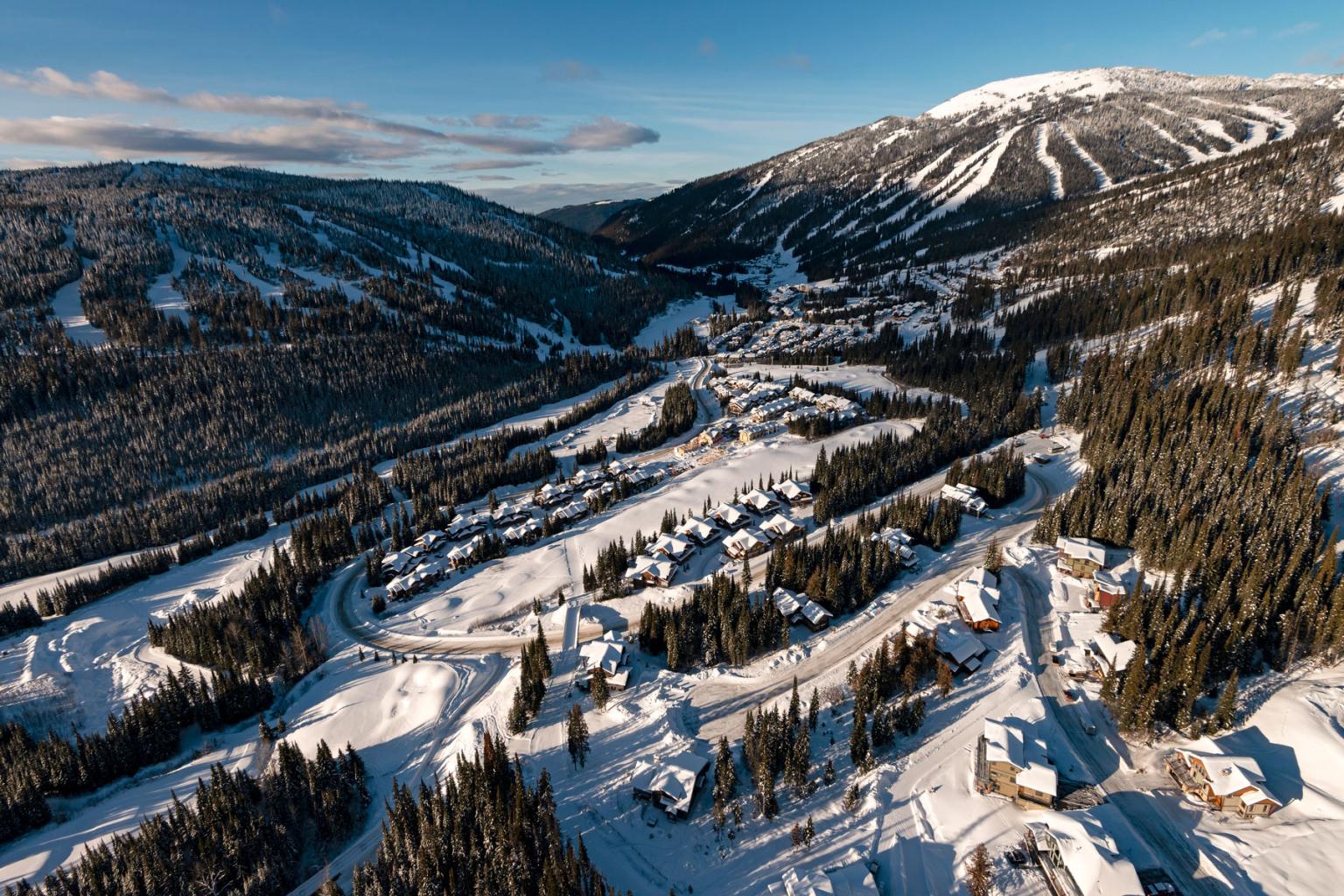Sun Peaks Village aerial view with mountains in the background in winter