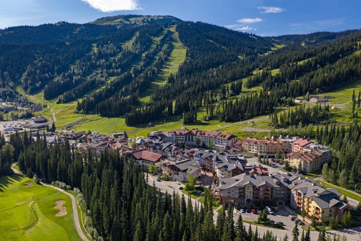 Sun Peaks Village aerial view with mountains in the background in summer